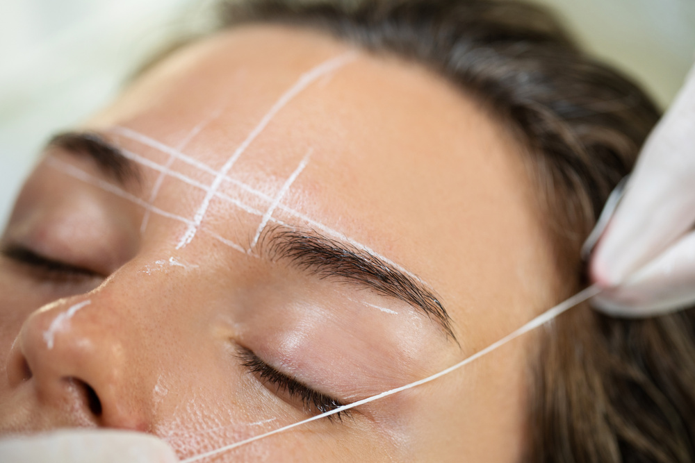 Woman during Professional Eyebrow Mapping Procedure